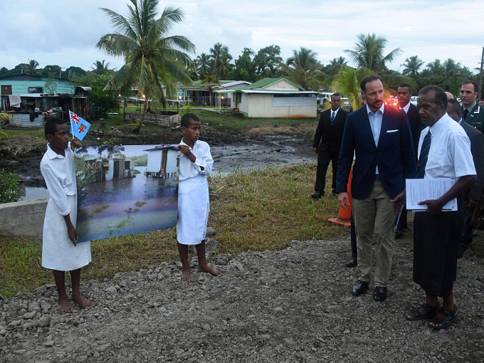 Children show pictures of how flood water has inundated the village. Photo: Sven Gj. Gjeruldsen, The Royal Court